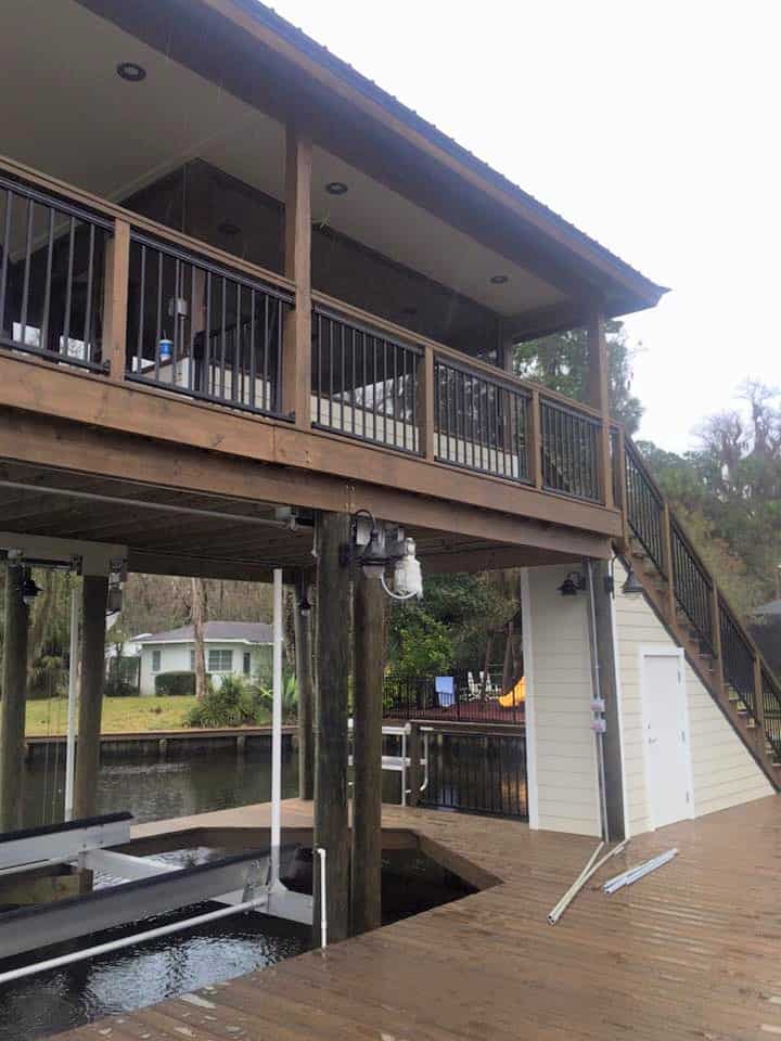Two-story boathouse from the deck, covered upper porch, stairs, storage room and boat lift below