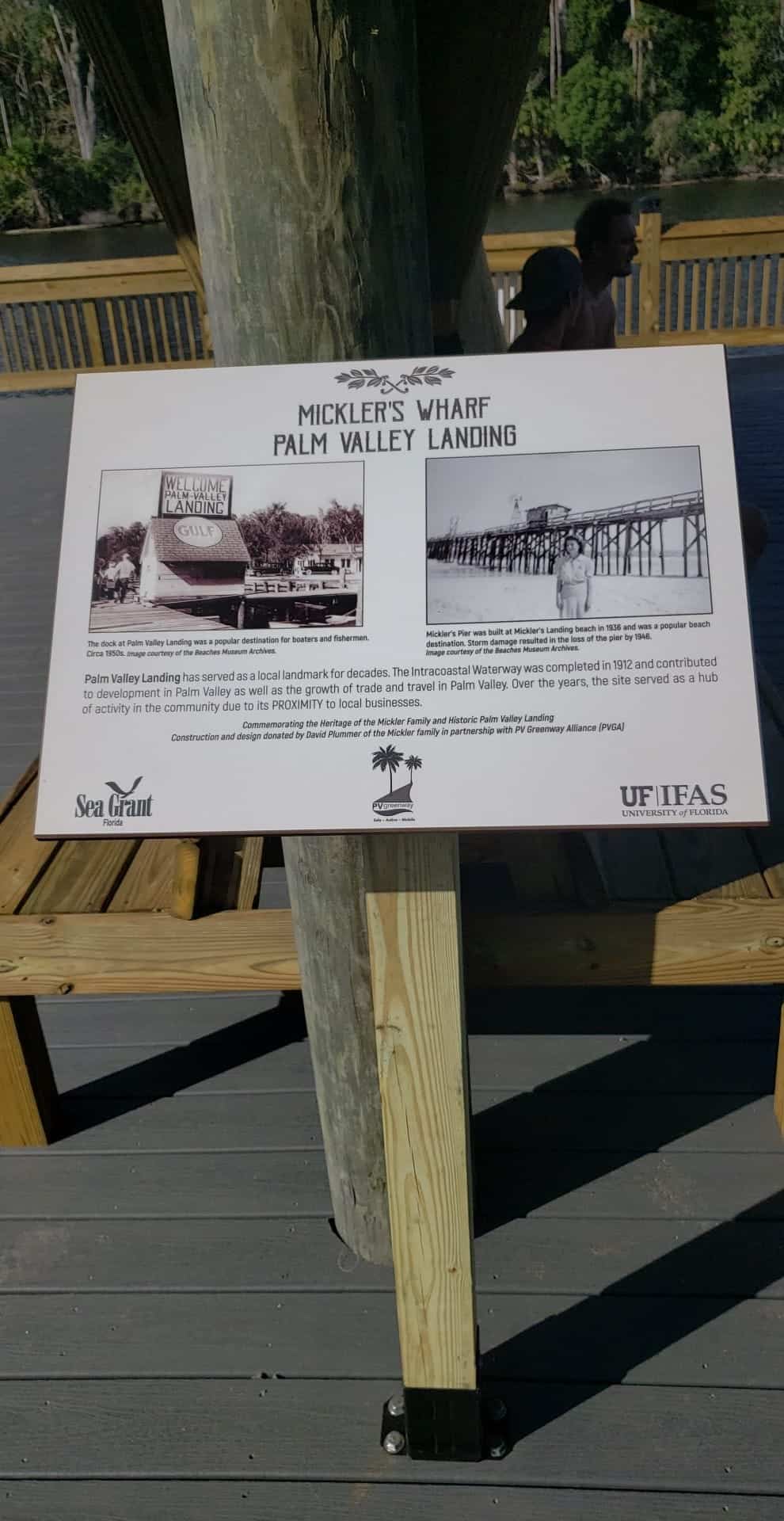 Interpretive sign about Mickler's Wharf and Palm Valley Landing mounted on a dock deck