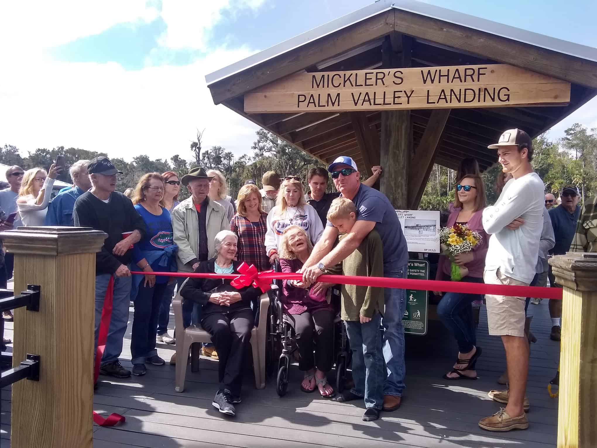 Crowd at a ribbon cutting under the Mickler's Wharf Palm Valley Landing pavilion